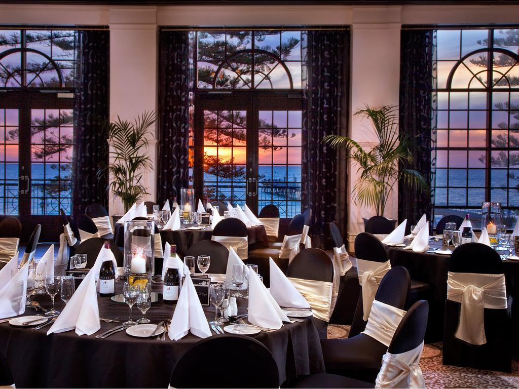Stamford Grand Adelaide Hotel Glenelg Bagian luar foto The photo shows an elegant dining setup inside a venue with large windows. The tables are adorned with black tablecloths and white napkins arranged in a stylish manner. Each table has glassware and other dining utensils placed neatly. In the backgrou
